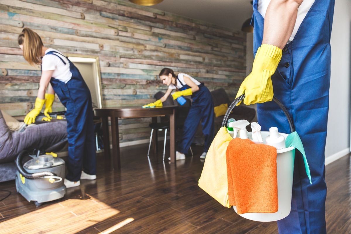 Cleaning service with professional equipment during work. professional kitchenette cleaning, sofa dry cleaning, window and floor washing. man and women in uniform, overalls and rubber gloves