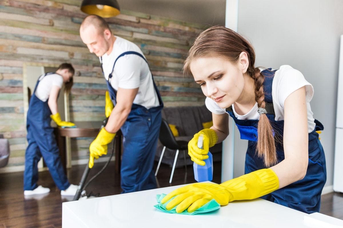 Cleaning service with professional equipment during work. professional kitchenette cleaning, sofa dry cleaning, window and floor washing. man and women in uniform, overalls and rubber gloves